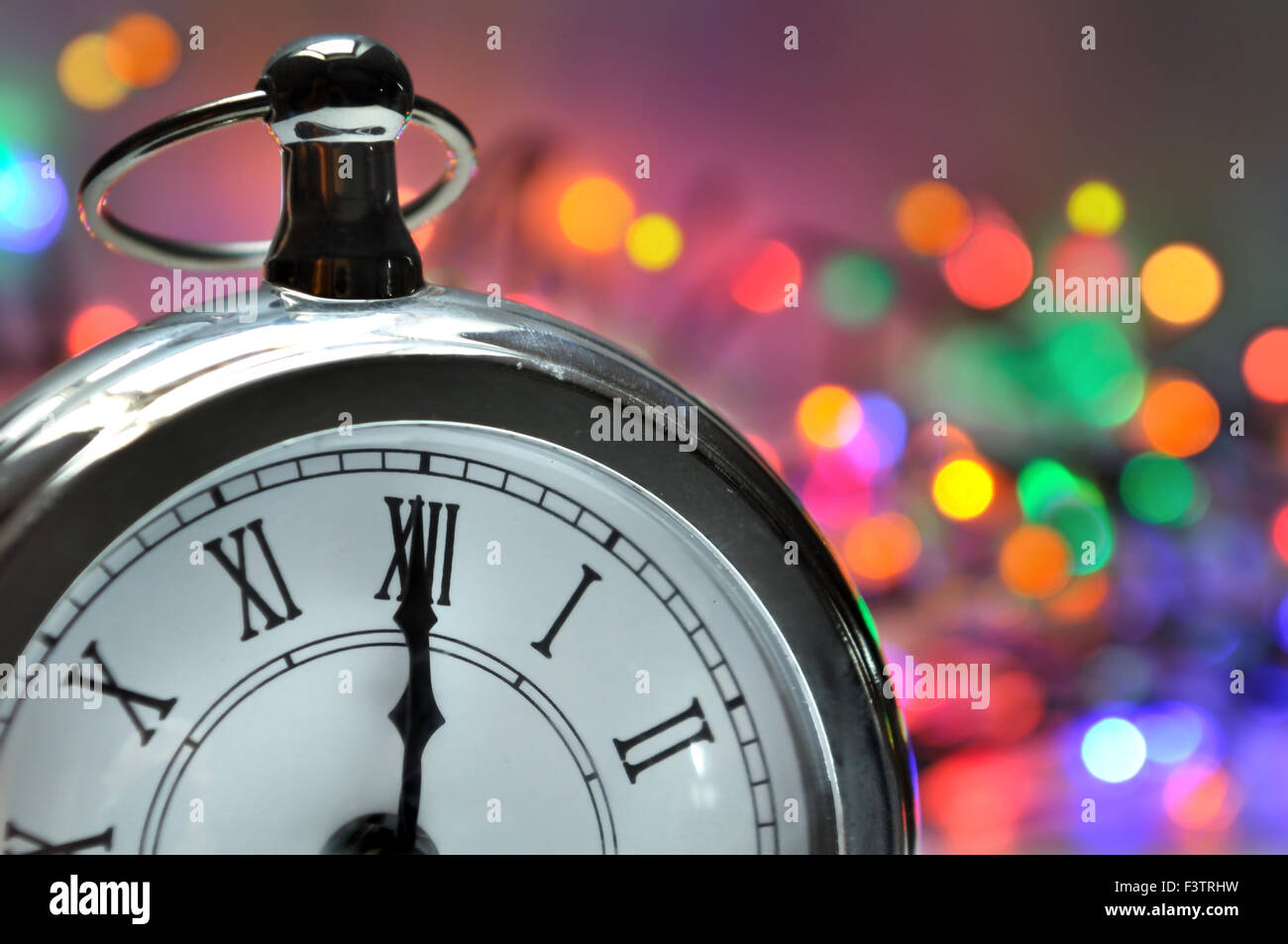 midnight on a clock with a colorful bokeh background Stock Photo