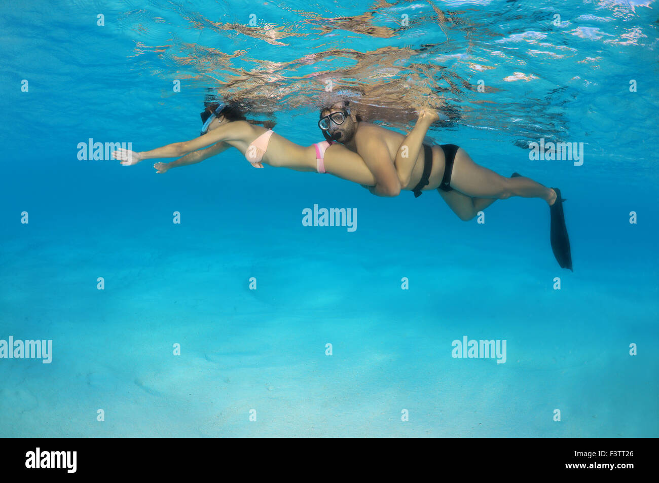 Young beautiful couple floating above a sandy bottom, Indian Ocean, Maldives Stock Photo
