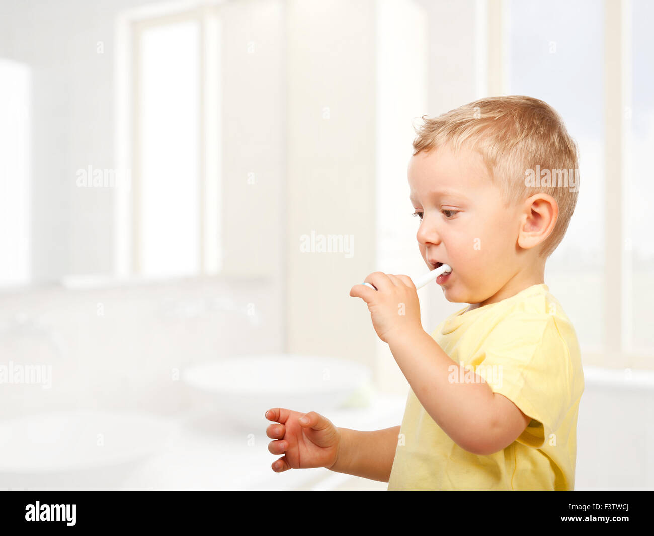 child brushing teeth in bathroom Stock Photo