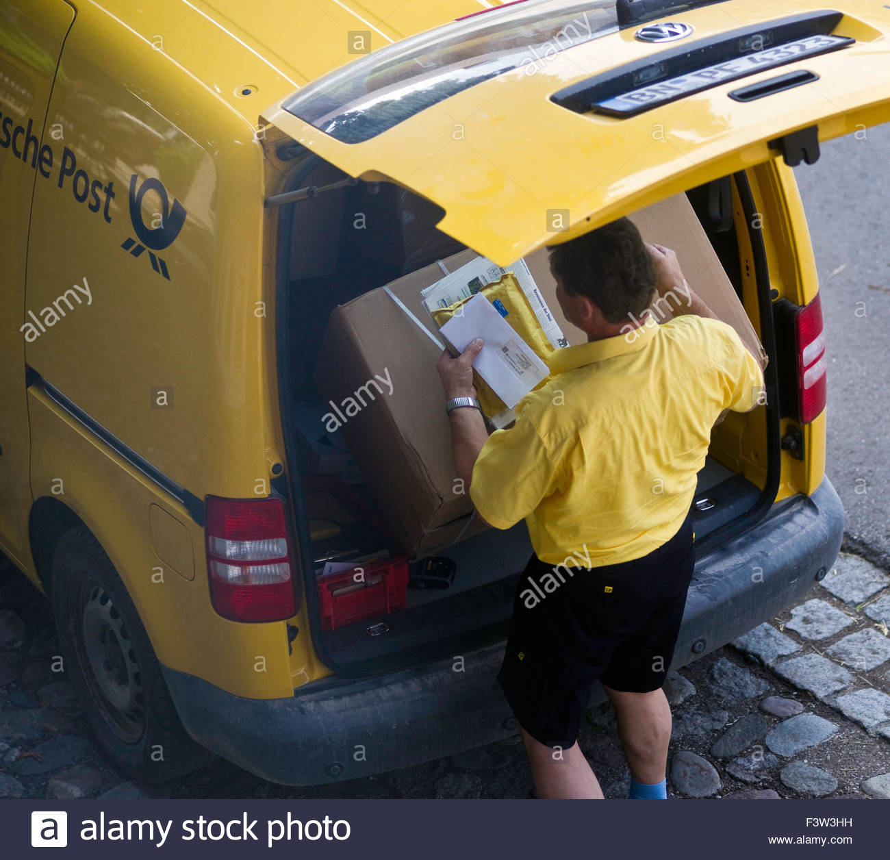 Deutsch Post Postman Delivering Cardboard Box Package Stock Photo Alamy