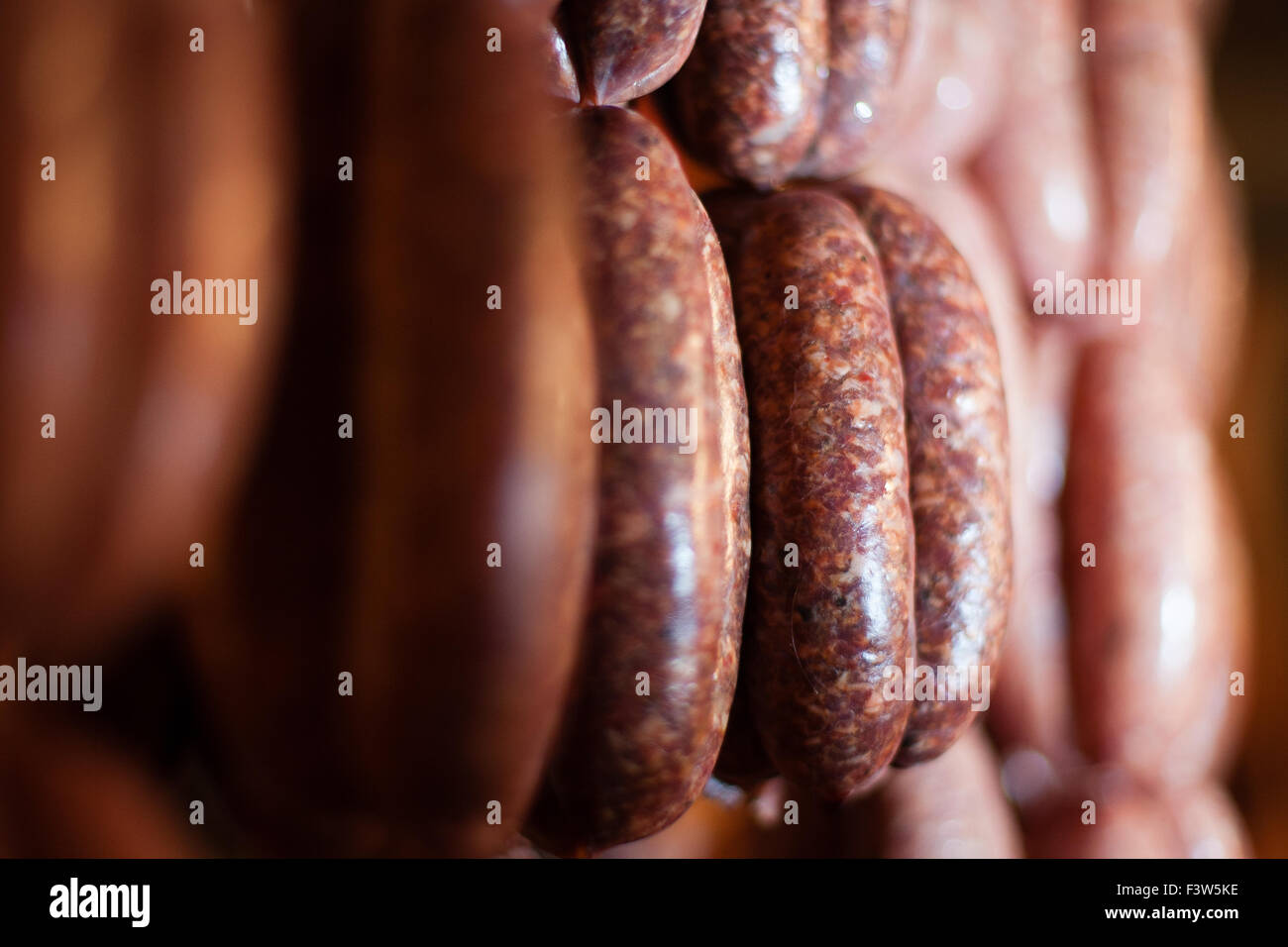 Handmade sausages of many varieties hang on display in a butchers shop