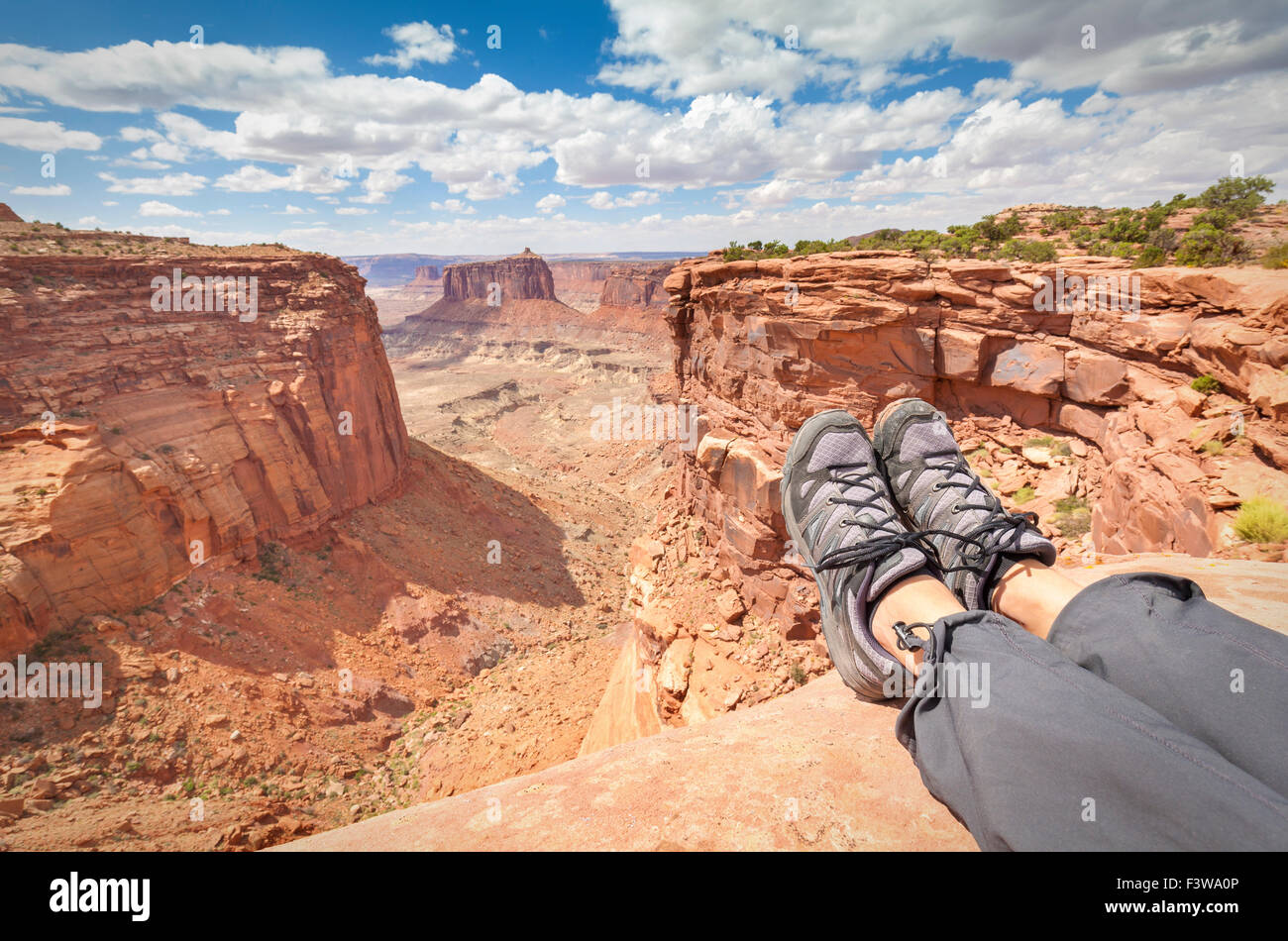 Resting tourist legs on top of a mountain, active holidays concept, shallow depth of field. Stock Photo