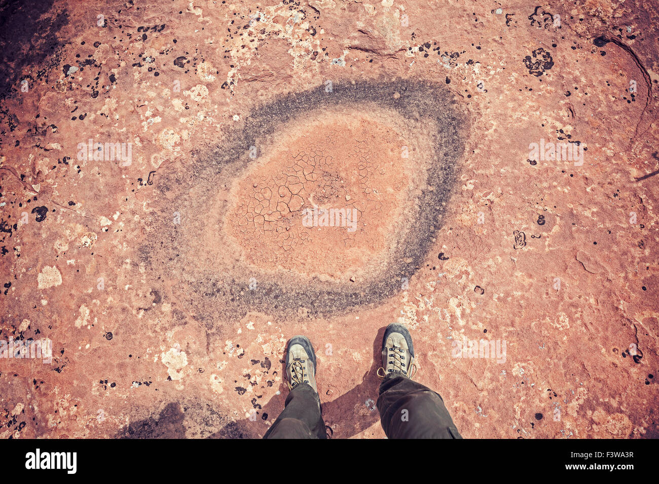 Feet standing in front of dried out puddle, climate change concept. Stock Photo