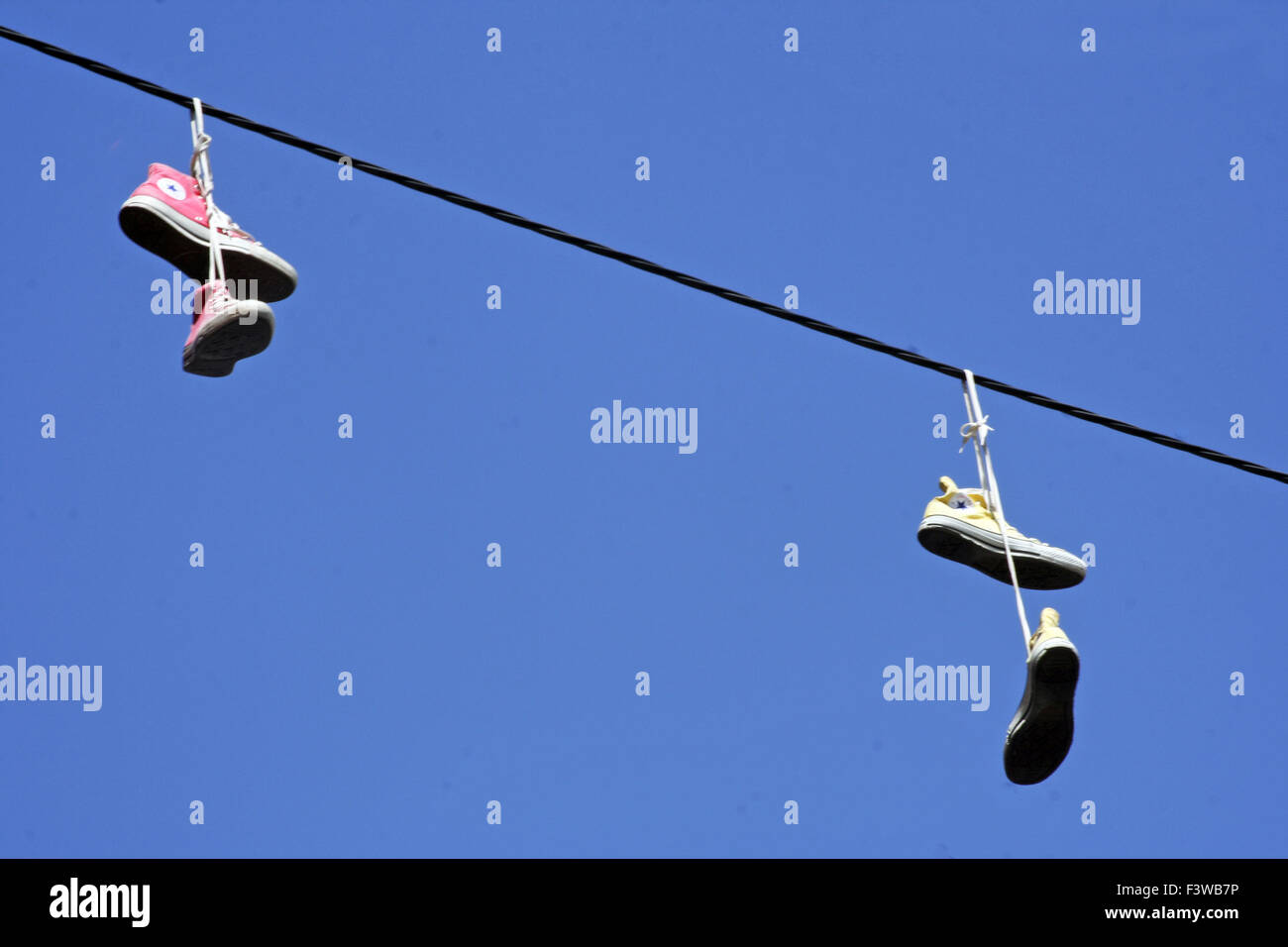 Converse training hanging on phone lines in Ibiza Stock Photo