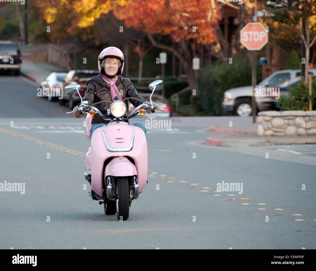 lady biker on pink scooter Stock Photo