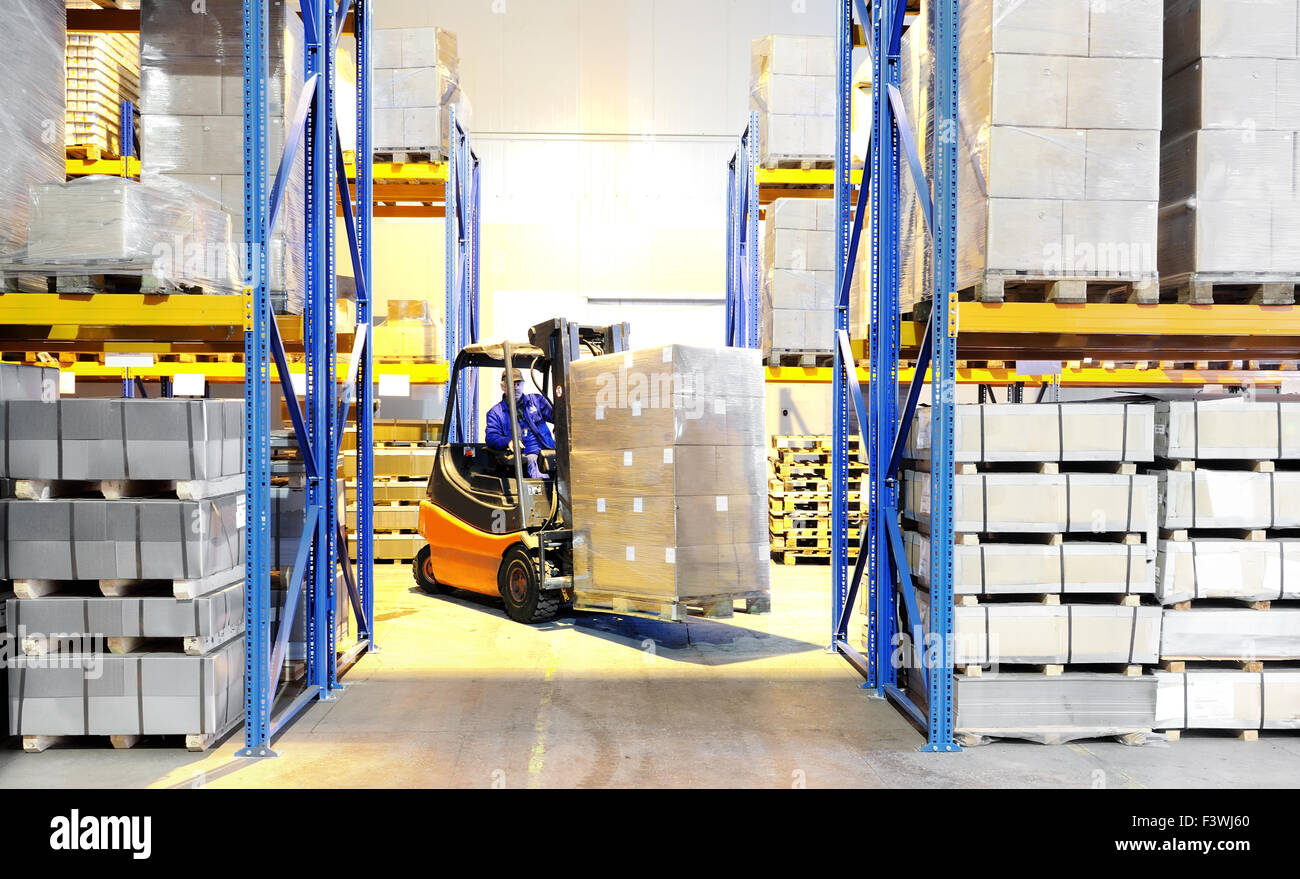 forklift loader and worker at warehouse Stock Photo