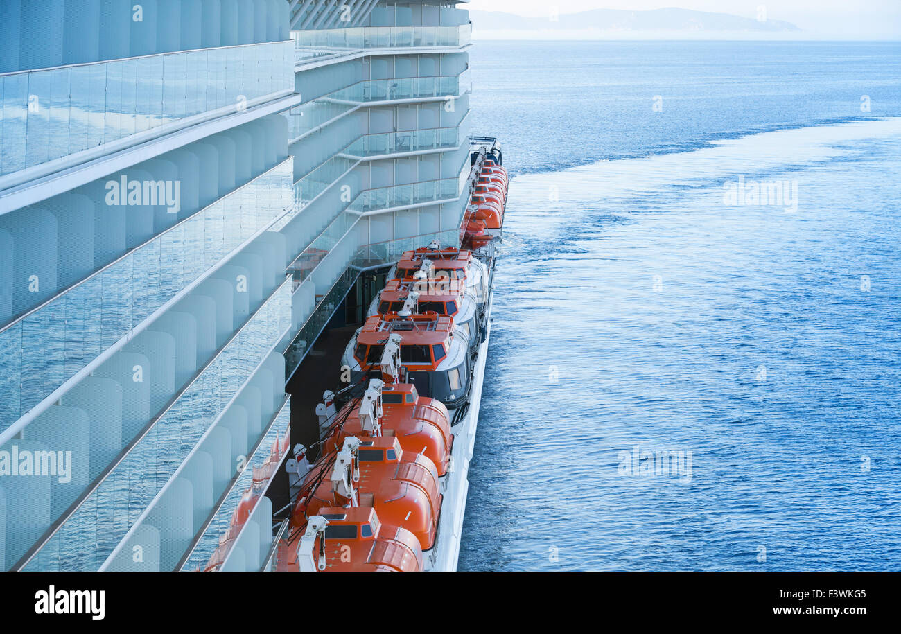 Red rescue boats in a row mounted on the deck of big passenger ferry Stock Photo