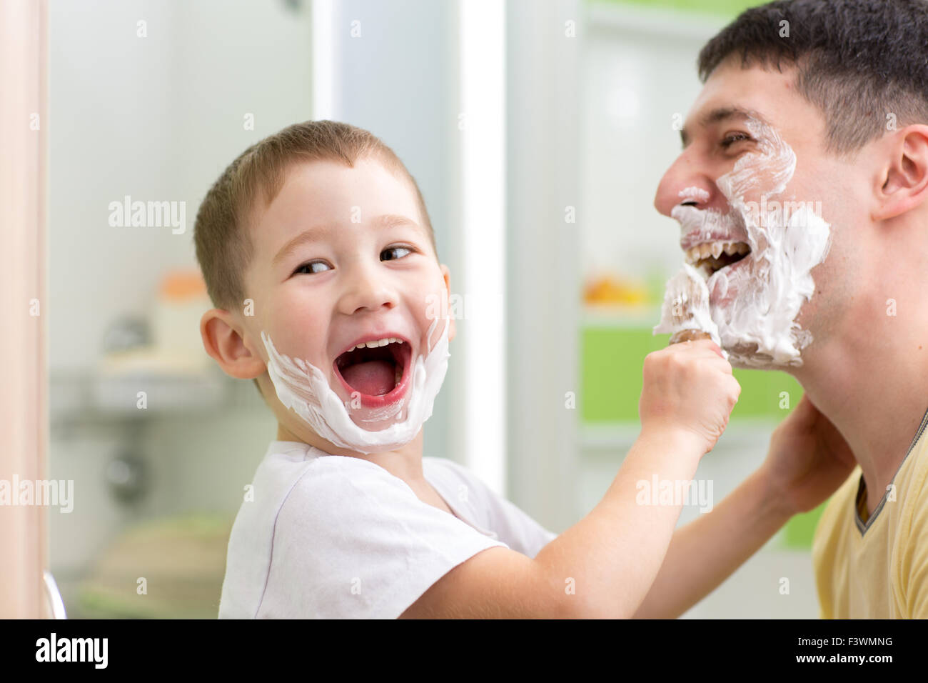 playful father and kid son shaving and having fun in bathroom Stock Photo
