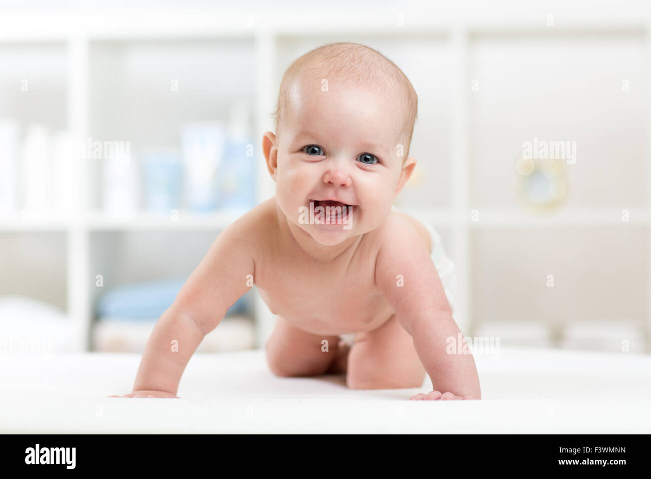 happy baby child crawling on bed and smiling Stock Photo Alamy