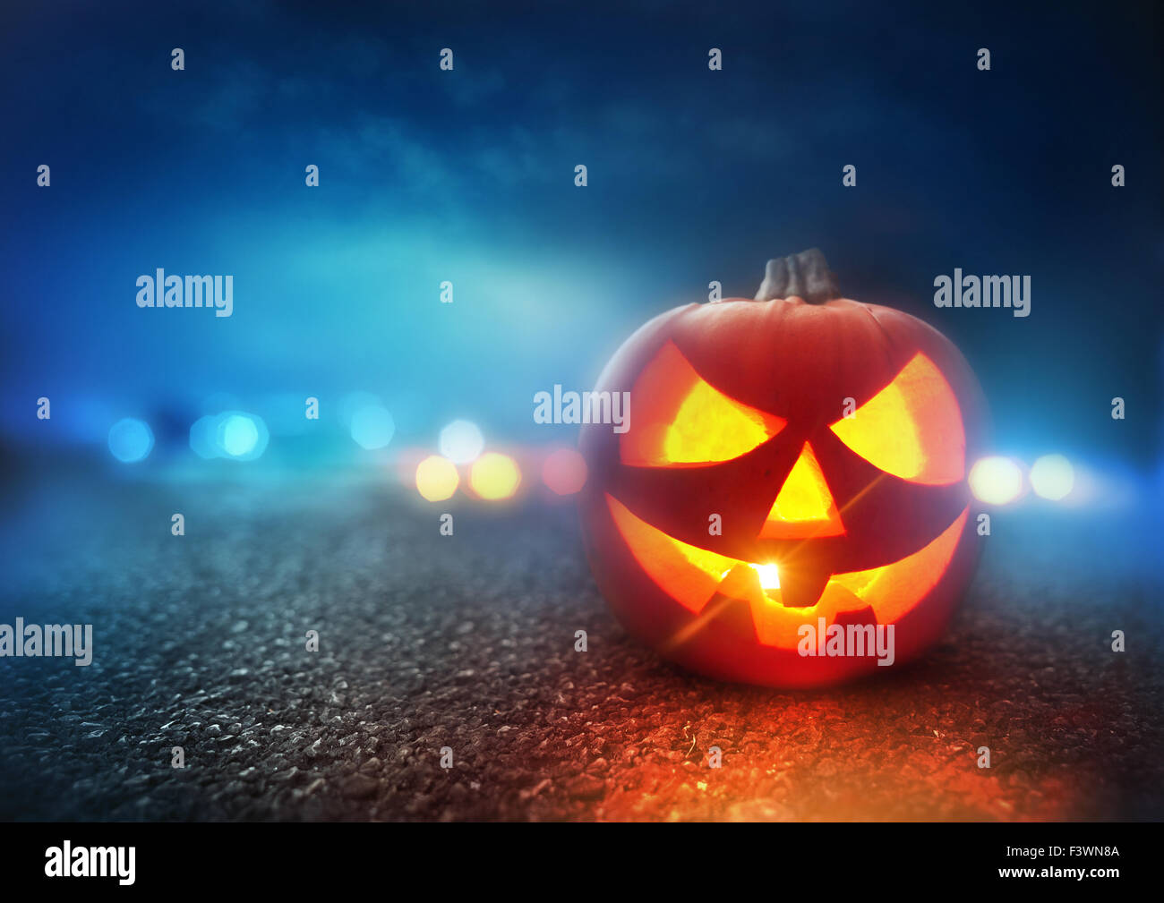 Halloween Night. A Jack O Lantern Pumpkin glowing orange on Halloween evening. Stock Photo