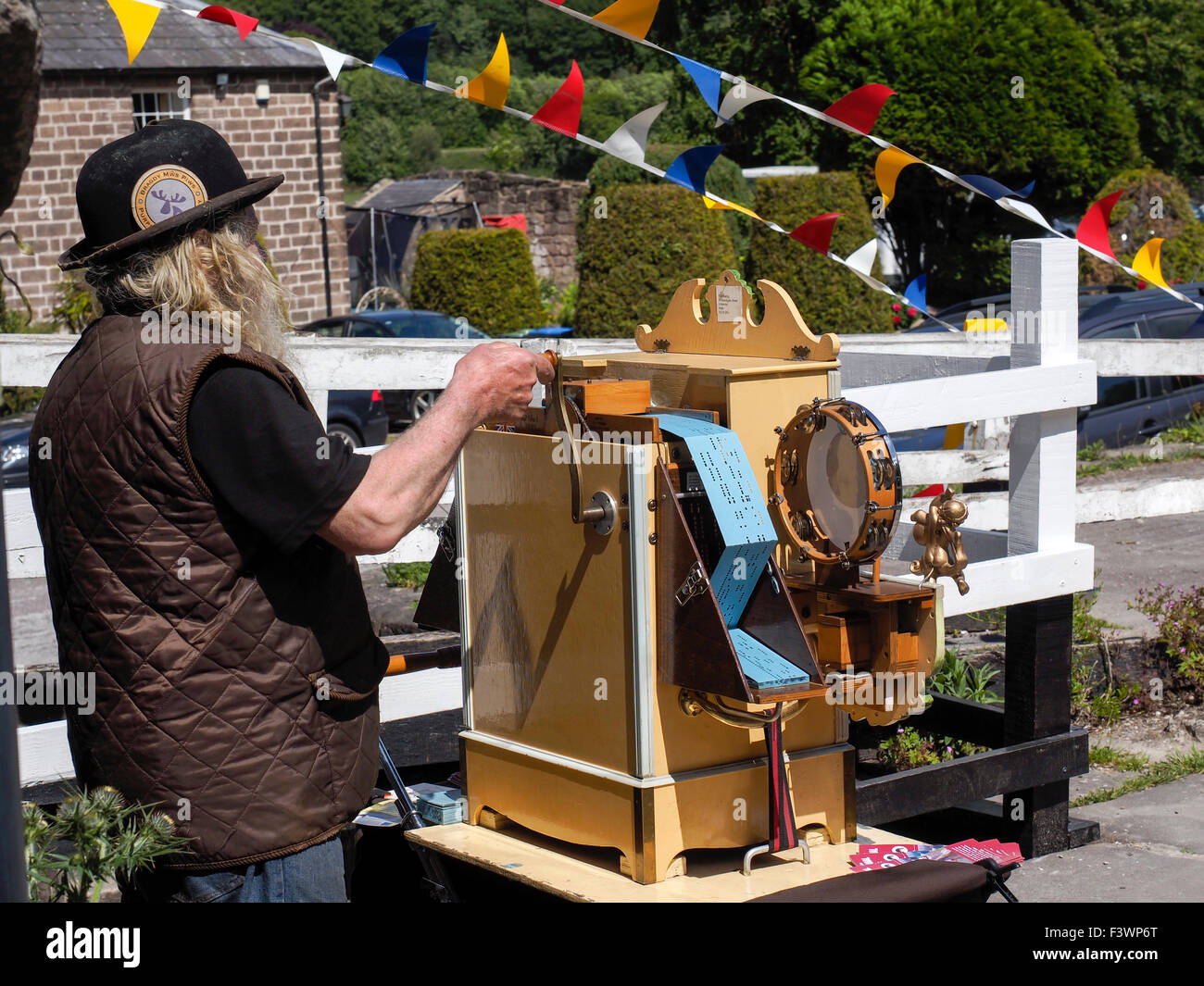 Man winding barrel organ in Derbyshire England Stock Photo