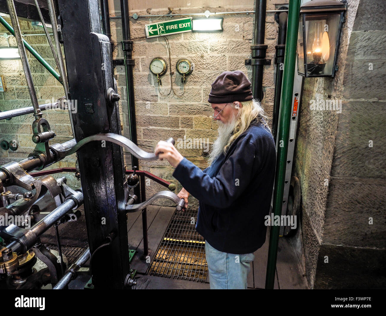 Old man operating equipment Leawood pump house on the Cromford canal in the Peak District Derbyshire England Stock Photo