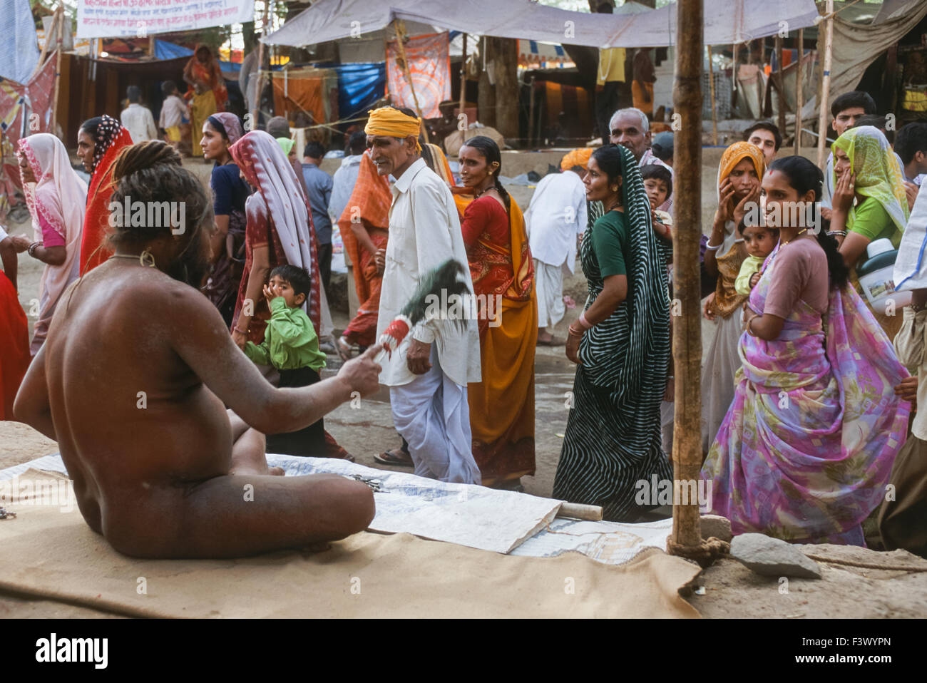 Naga (naked) Sadhu from the Juna Akhara looking out to passing pilgrims from his ashram, Simhastha Kumbh Mela 2004, Ujjain, Madhya Pradesh, India Stock Photo