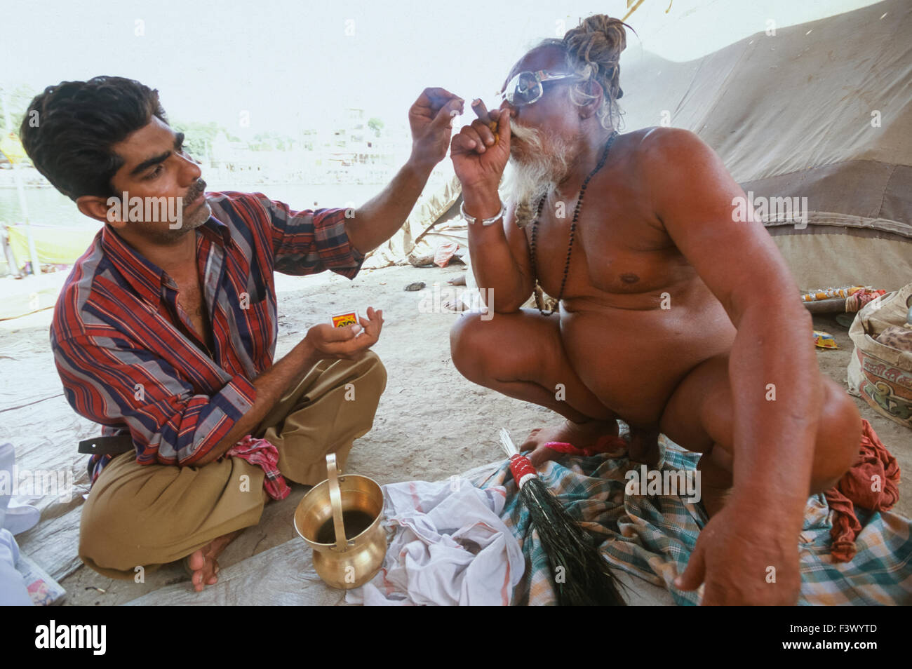 Naga Sadhu from the Juna Akhara smoking a chillum of charras (hashish) at his ashram, Simhastha Kumbh Mela 2004, Ujjain, Madhya Pradesh, India Stock Photo