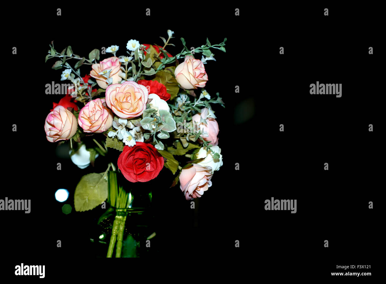 colorful of rose artificial flower in green vase on black background Stock Photo