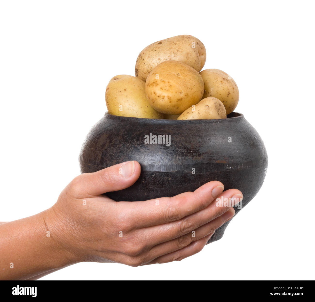 cast iron pot with a potato in the hands Stock Photo