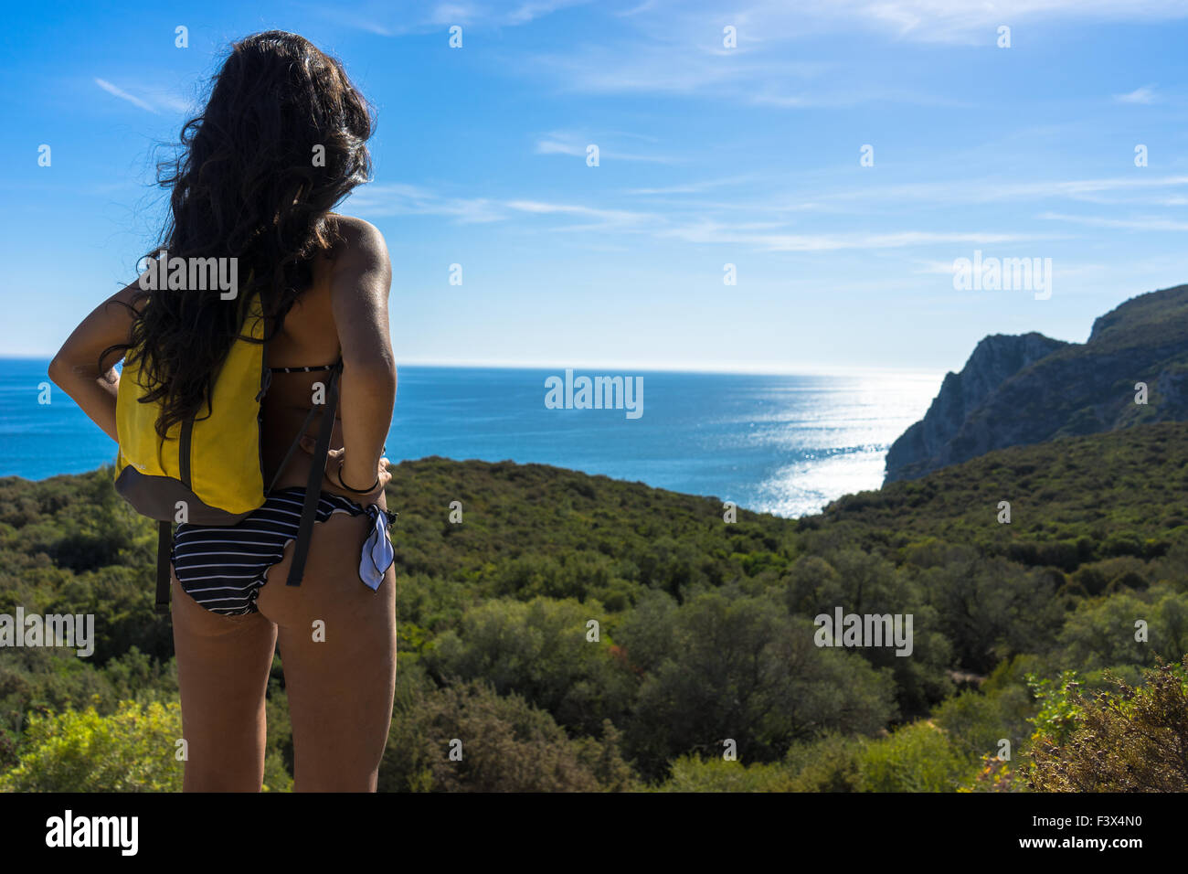 Beautiful woman hiker in a bikini looks over the land to the sea. September, 2015. Stock Photo