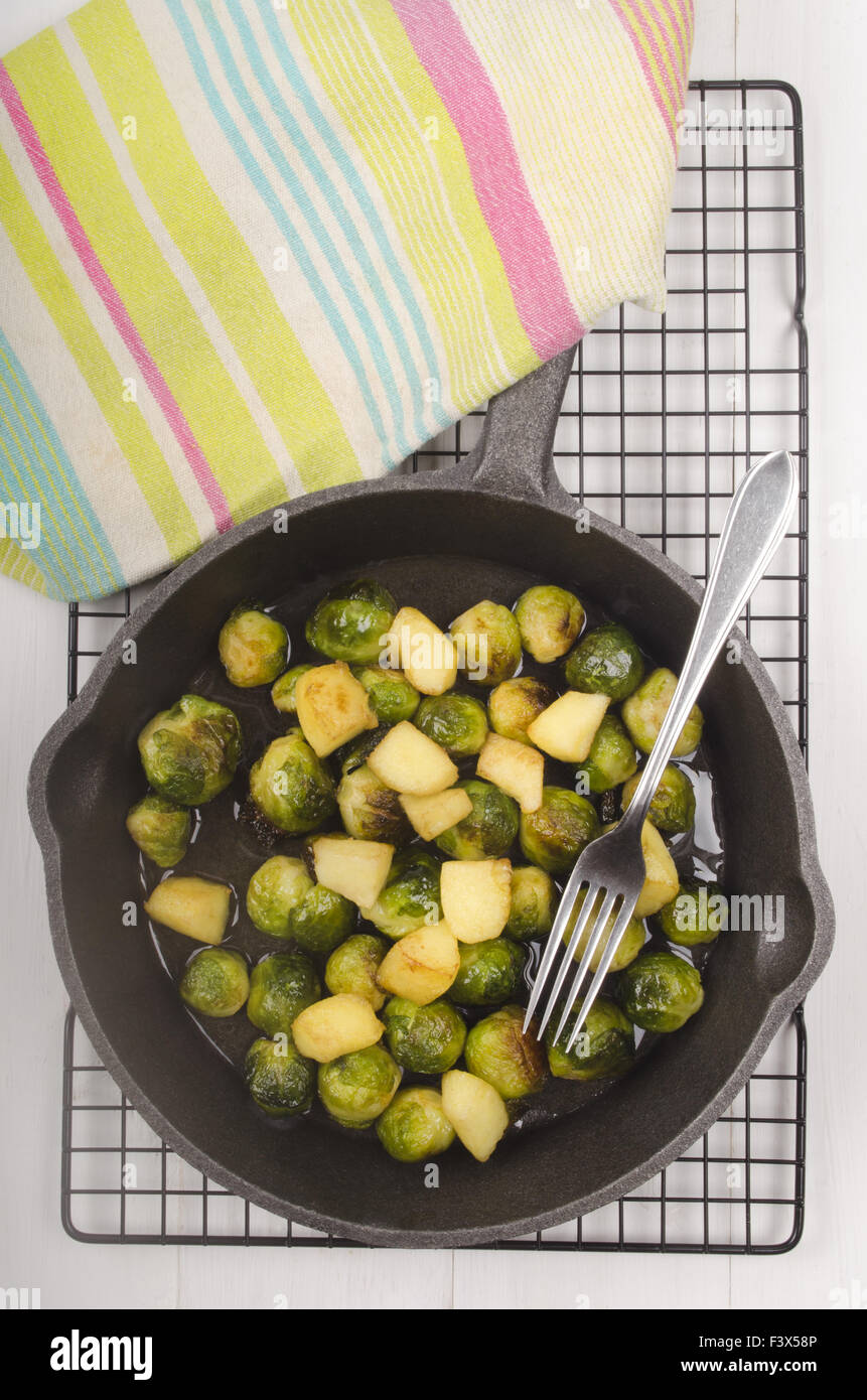 roasted brussels sprouts with apple in a cast iron pan Stock Photo