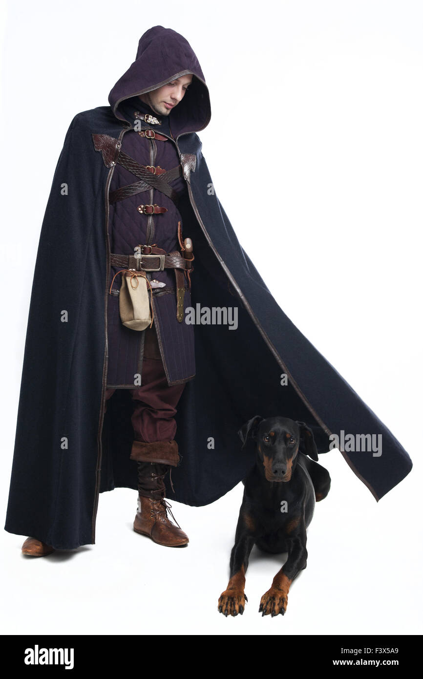 Young man in medieval garb and doberman Stock Photo