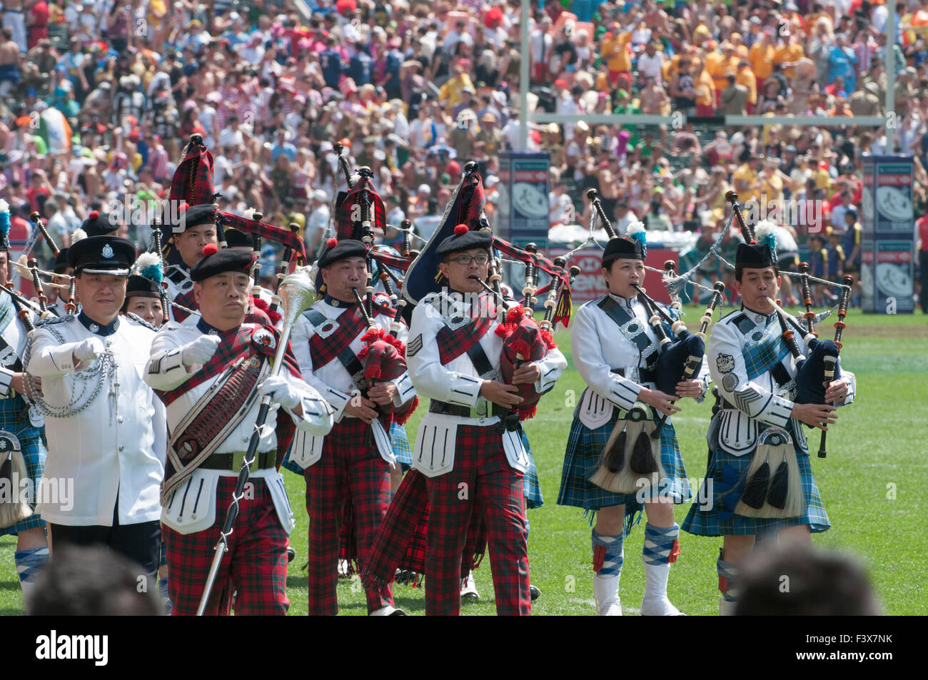 Asian Drum Major leading bagpipers in a parade after a sevens rugby match in Hong Kong Stadium, China Stock Photo