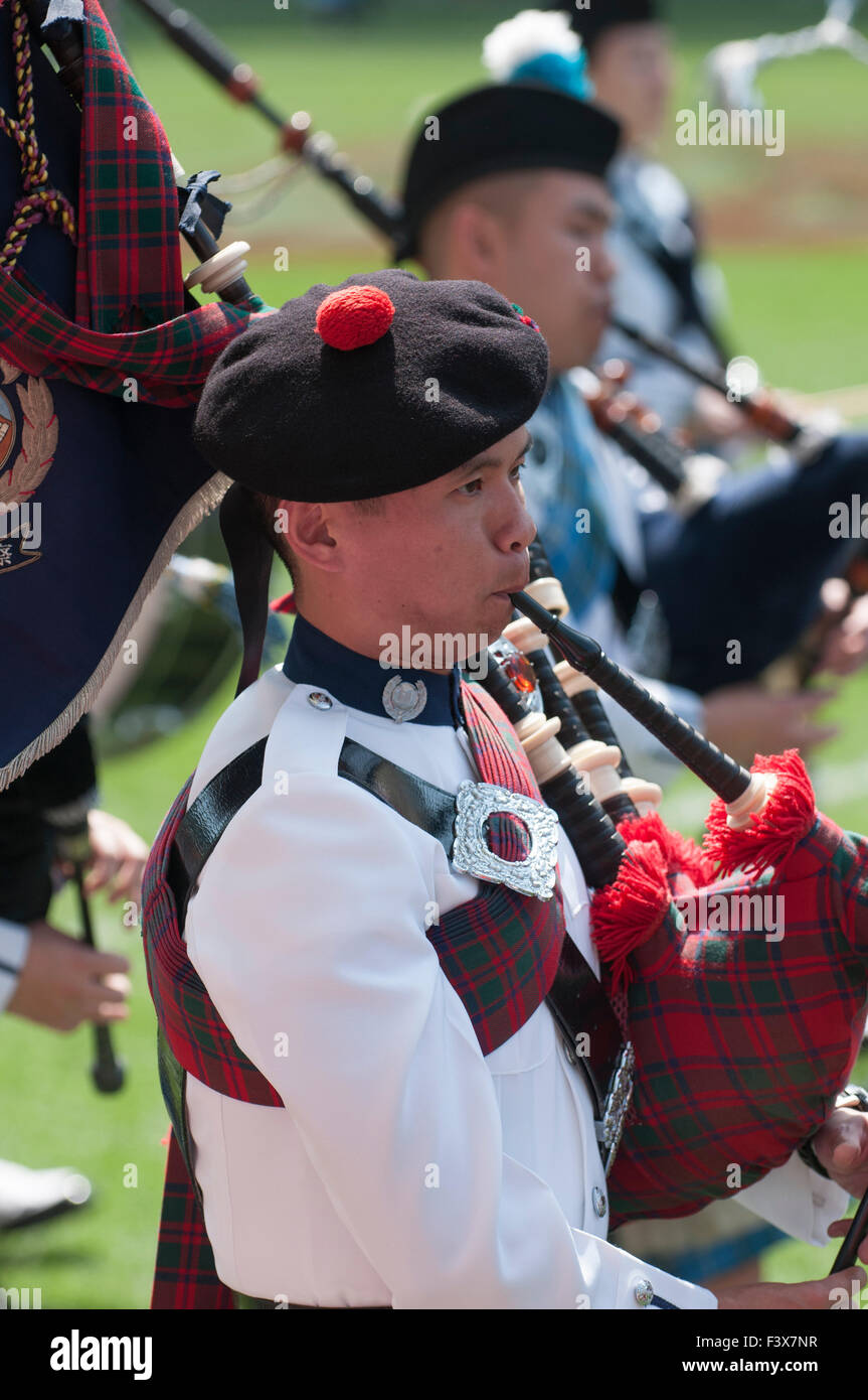 Asian Bagpiper parading after a sevens rugby match in Hong Kong Stadium, China Stock Photo