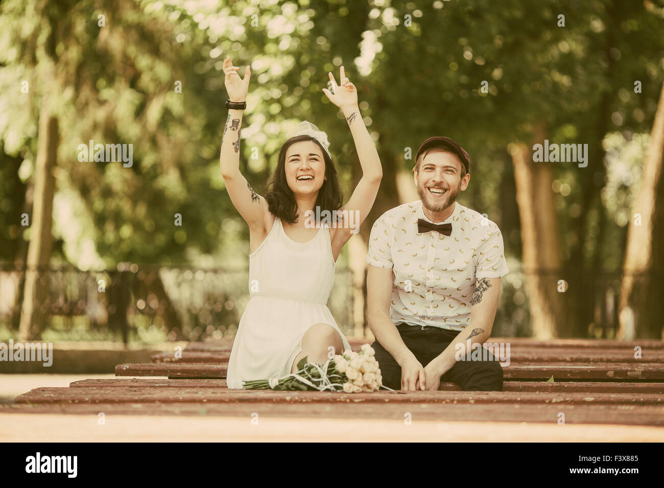 beautiful couple sits on a bench in the park and having fun Stock Photo ...