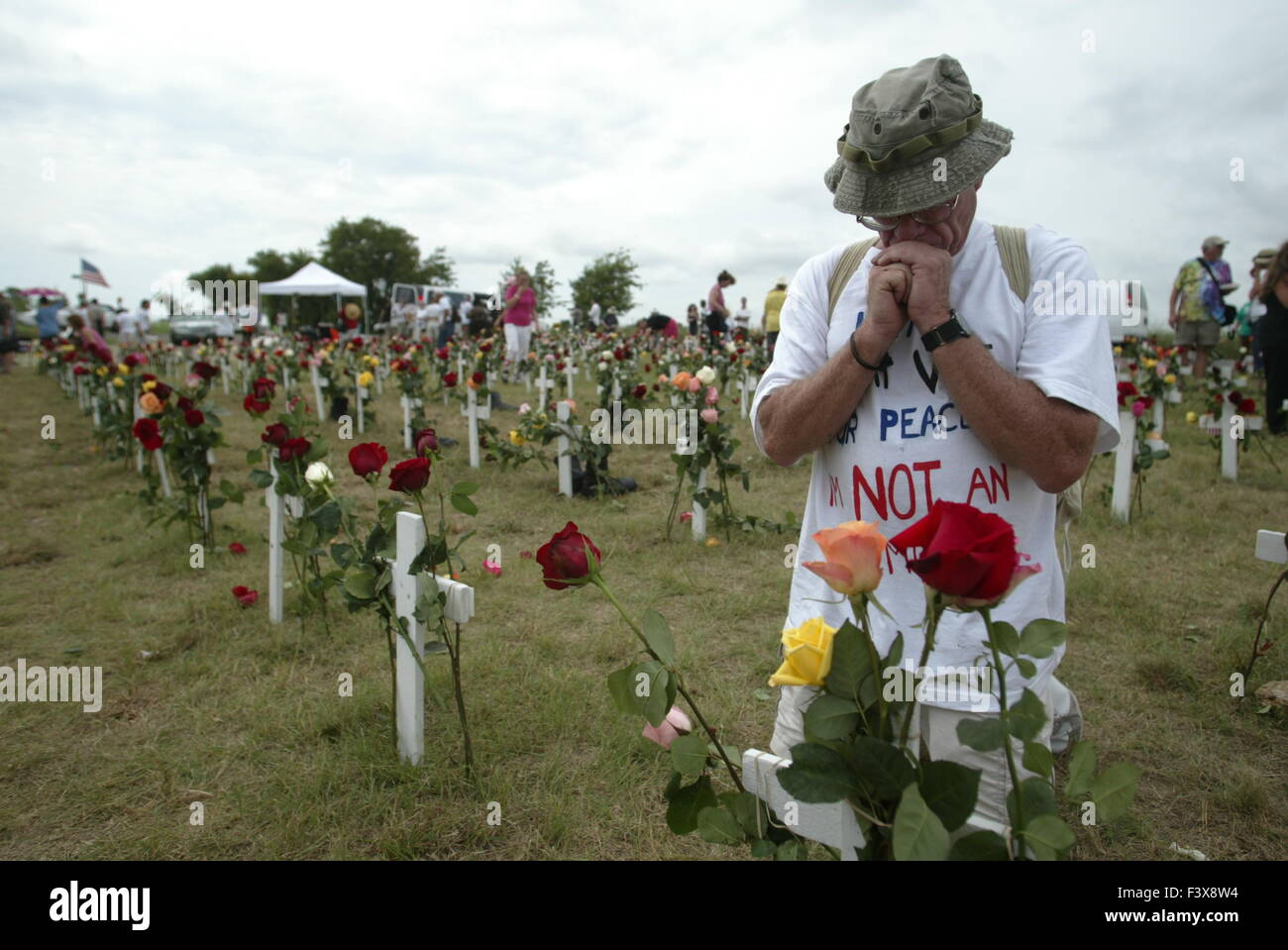 a man is overcome by emotion after placing a flower on a crosst at Camp Casey II Stock Photo