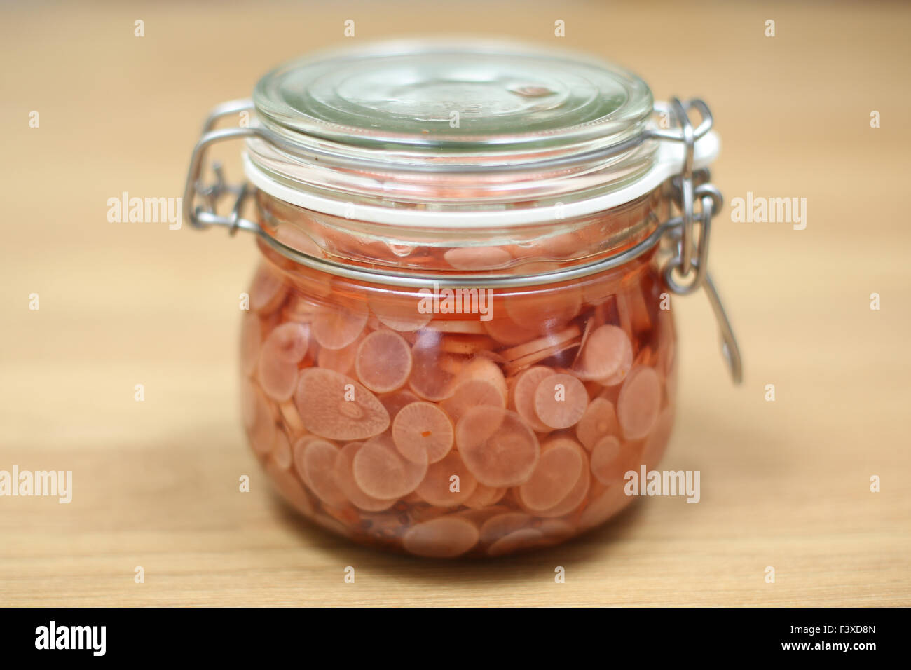 A jar of sliced and pickled radishes. Stock Photo