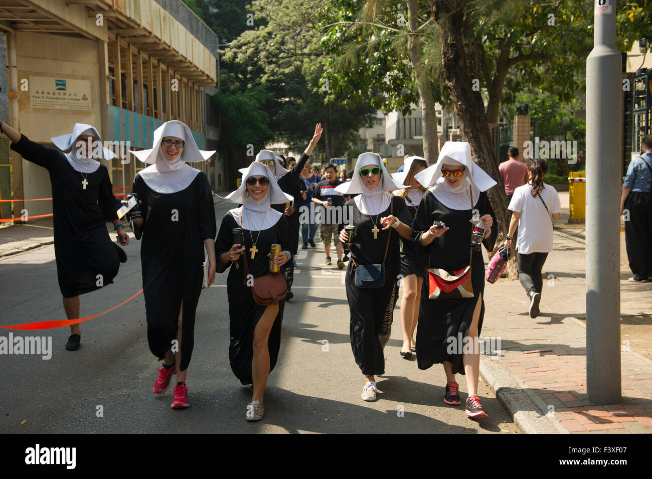 Sport fans on the way to Hong Kong Stadium dressed has nuns Stock Photo