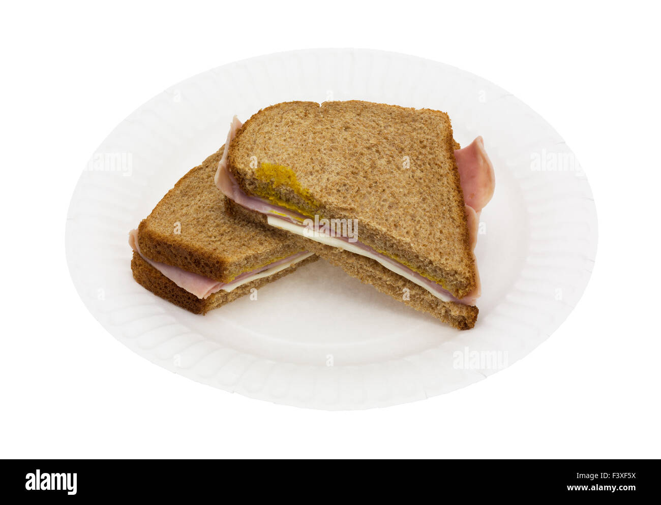 A ham and cheese sandwich that has been cut in half on a white paper plate atop a white background. Stock Photo