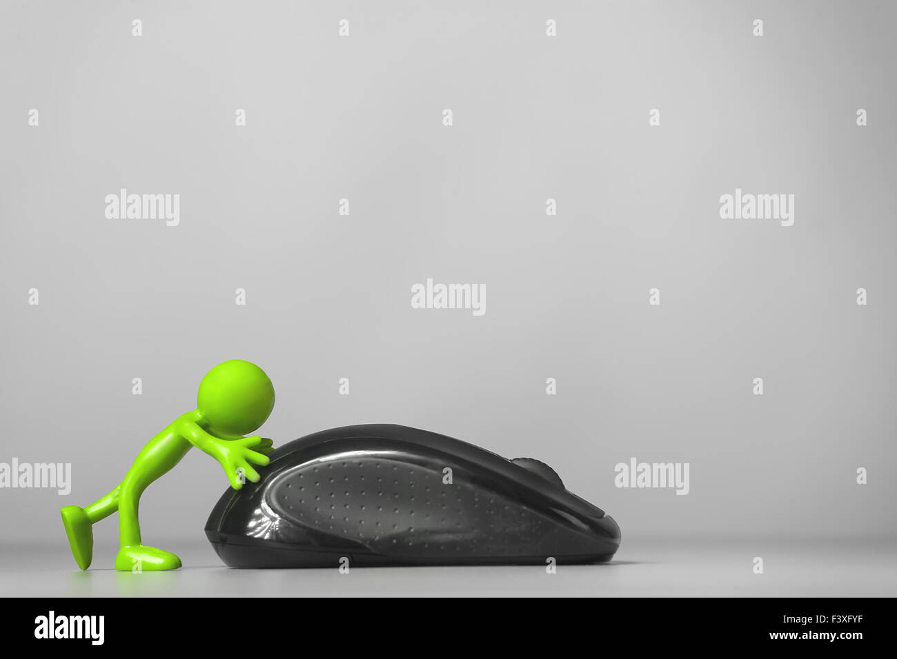Green man pushing a computer mouse. Stock Photo
