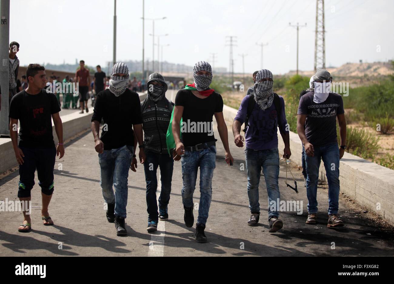 Erez, Gaza Strip, Palestinian Territory. 13th Oct, 2015. Palestinian protesters clash with Israeli security forces next to the border fence with Israel, at the Erez crossing in the northern Gaza strip, on October 13, 2015. A wave of stabbings that hit Israel, Jerusalem and the West Bank this month along with violent protests in annexed east Jerusalem and the occupied West Bank, has led to warnings that a full-scale Palestinian uprising, or third intifada, could erupt. The unrest has also spread to the Gaza Strip, with clashes along the border in recent days leaving nine Palestinians dead from Stock Photo
