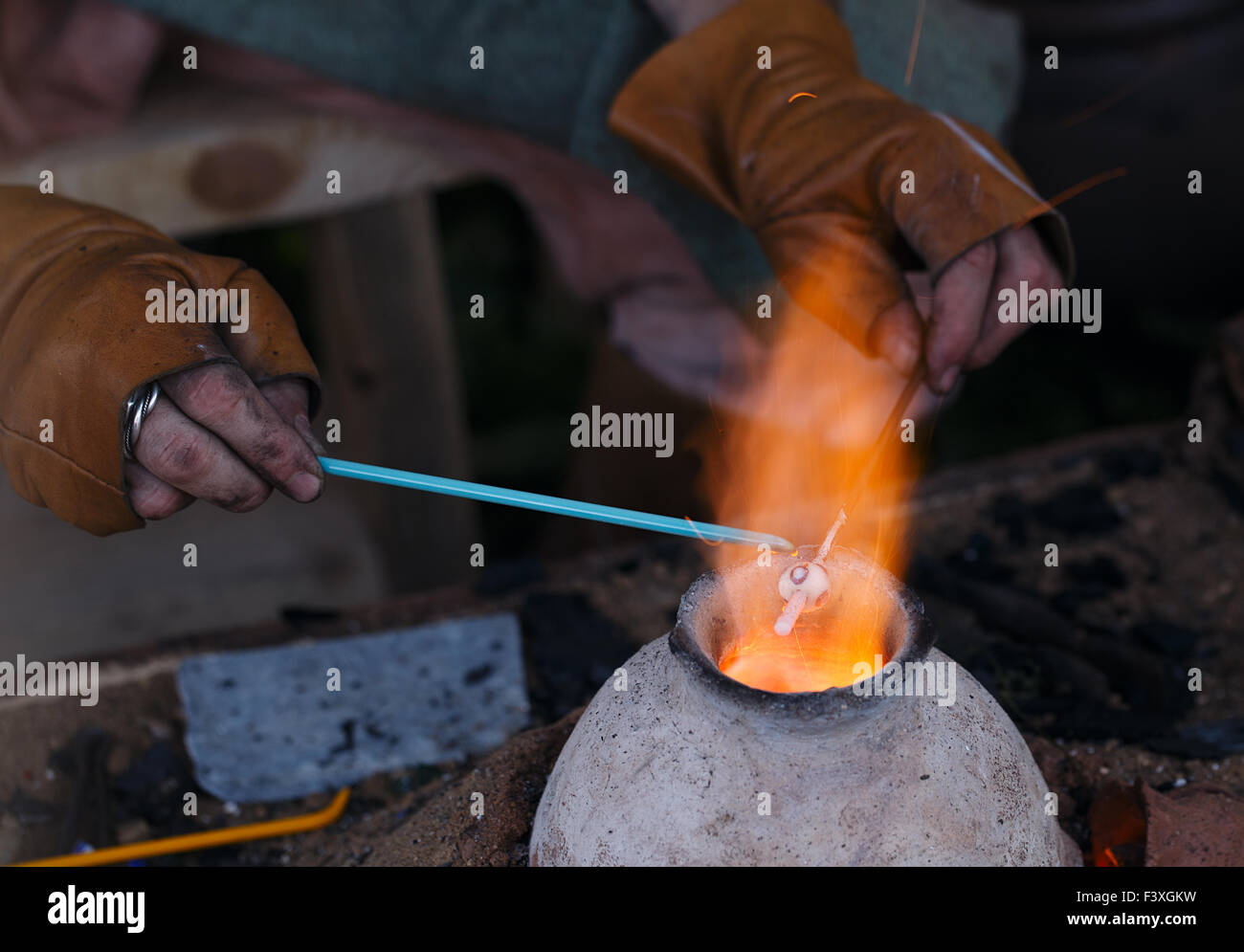 A glass blowing artist forms a blob of glass into a vessel using a gas torch  in Vermont Stock Photo - Alamy