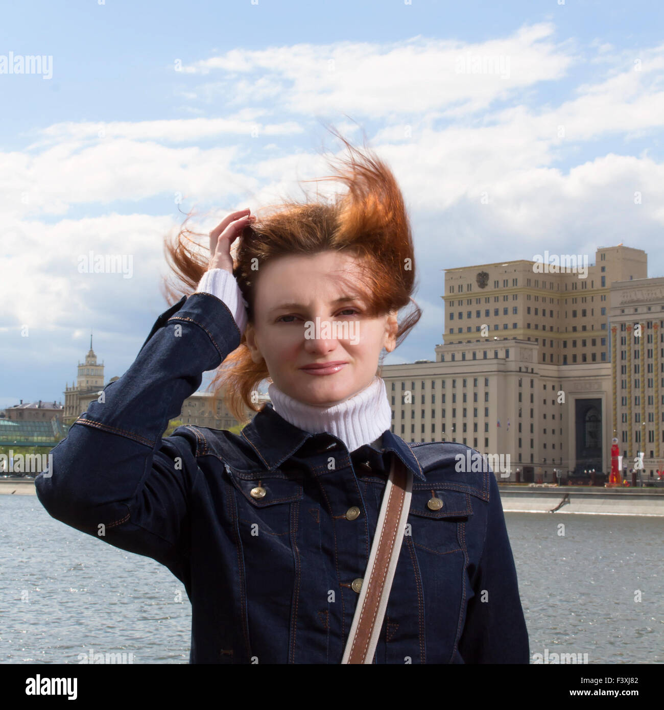 Portrait of girl with hair flying on the embankment of the Moscow River. With views of the Ministry of Defense of the Russian Stock Photo