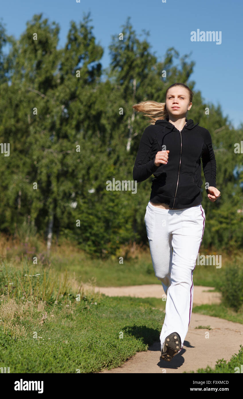 Girl running in the park. Wide shot Stock Photo