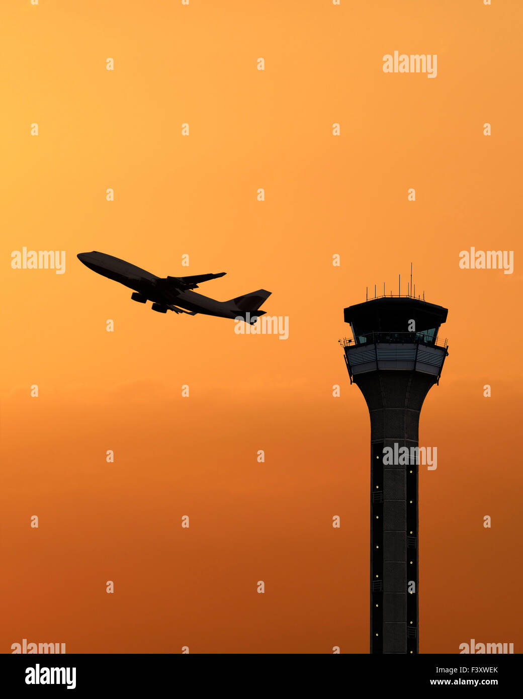 Air traffic control tower with a plane taking off at sunset. Luton Airport, UK. Stock Photo