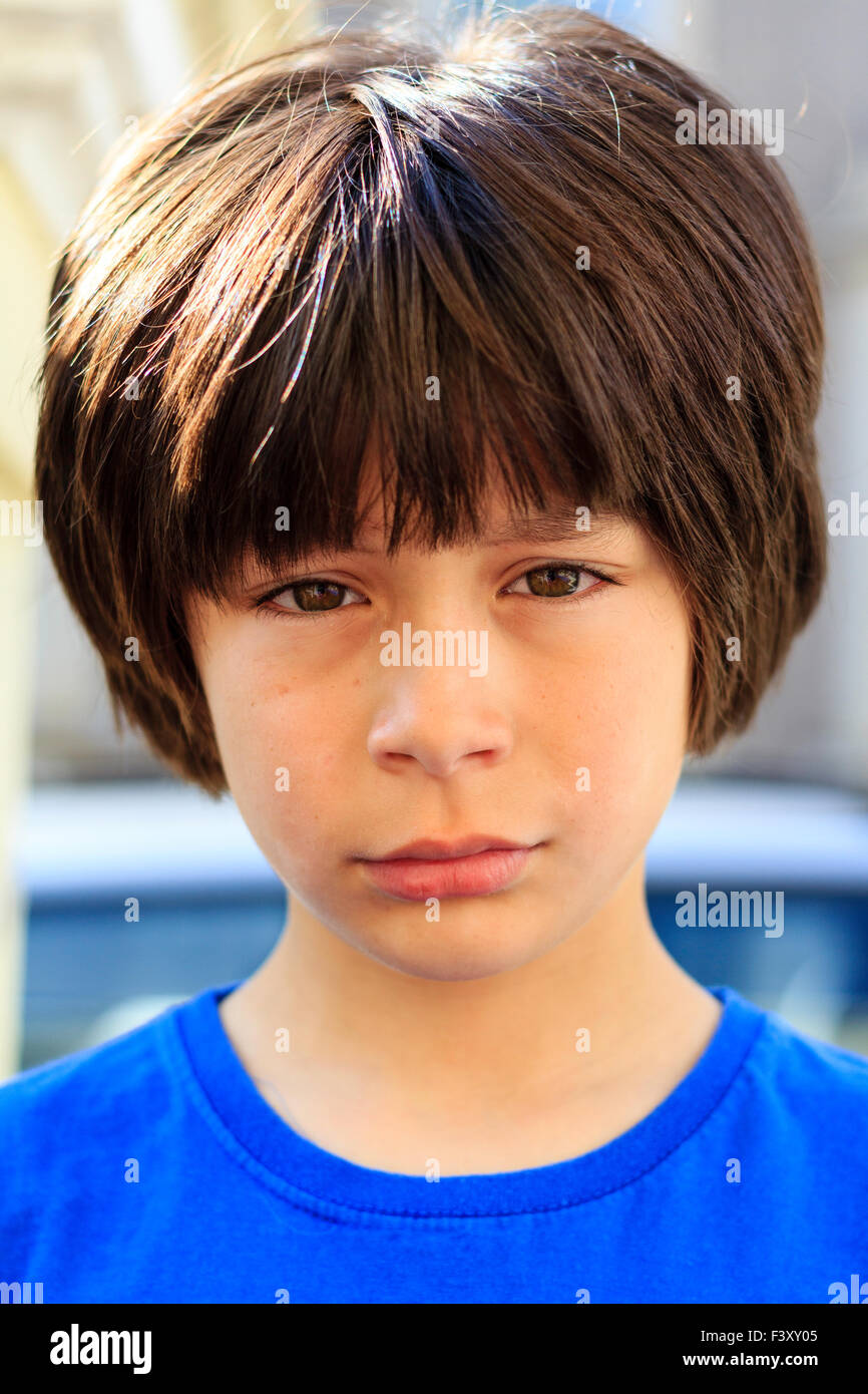 Brown haired Caucasian child, boy, 910 year old, standing outdoors in