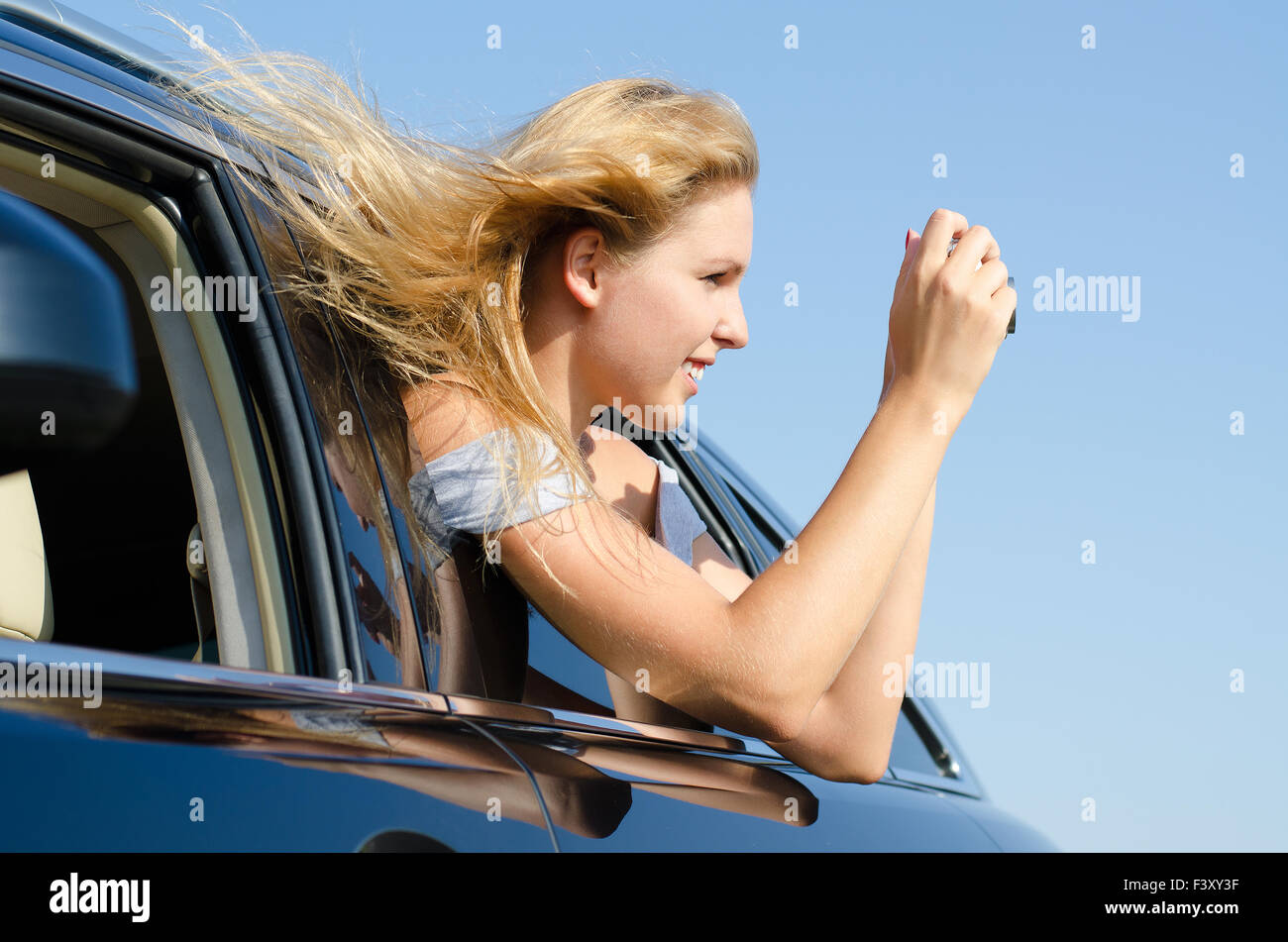 Woman in car taking photographs Stock Photo