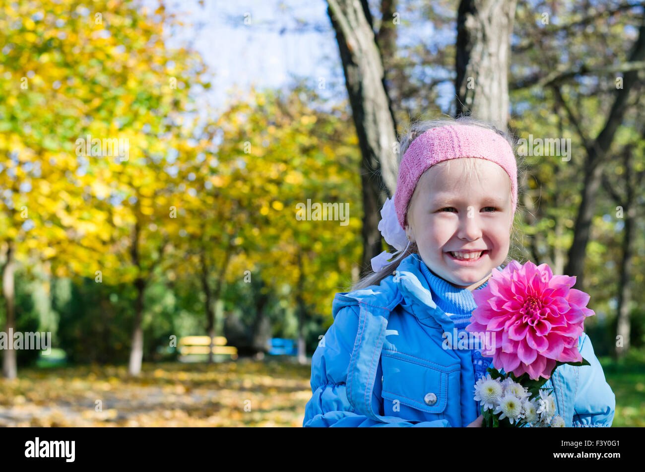 Happy young girl posing with a dahlia Stock Photo