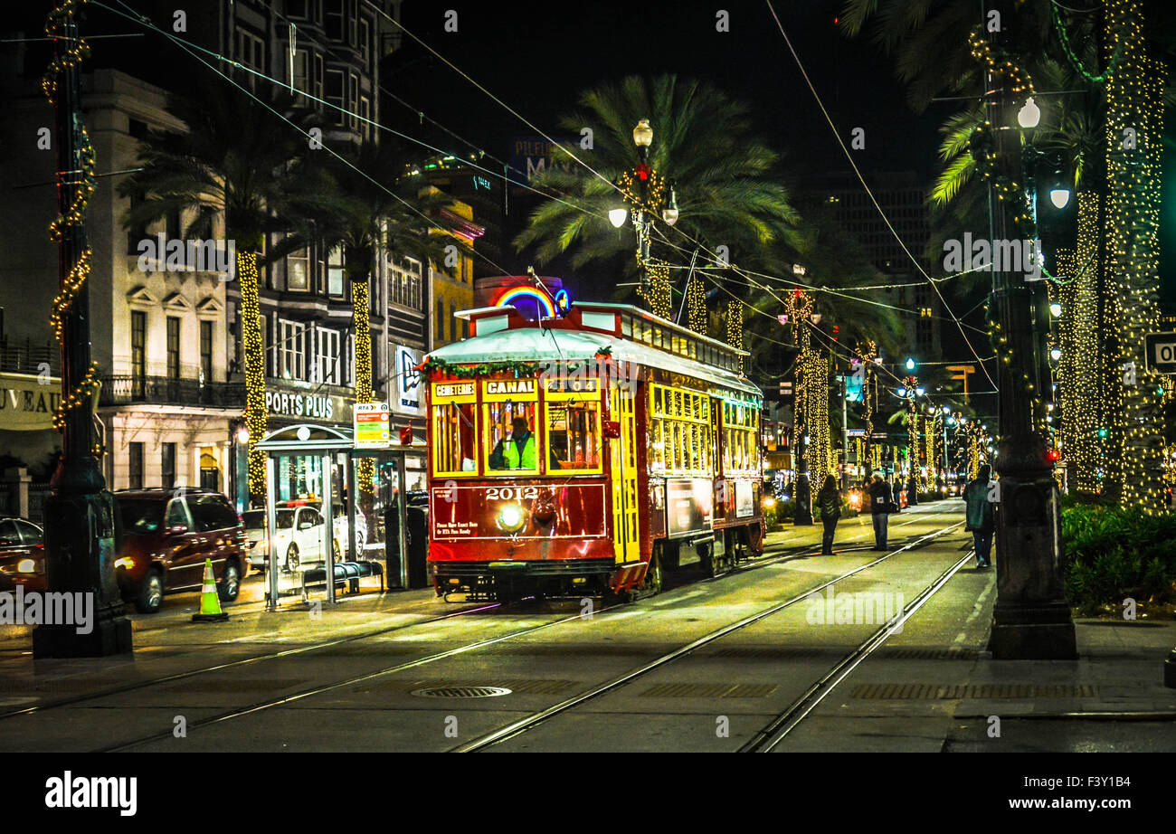 The Canal Streetcar at night among the neon lights and palm tree lighting makes for a festive ambiance in New Orleans, LA Stock Photo