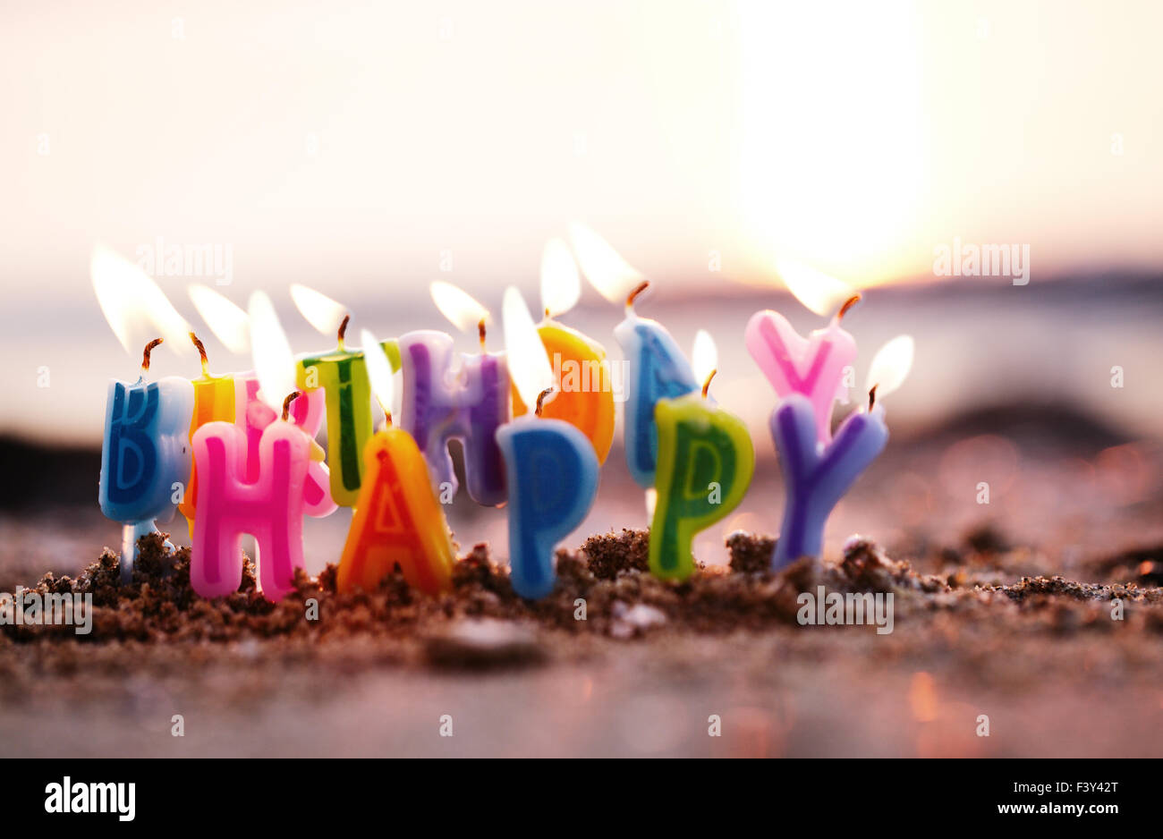 Birthday candles burning on a seashore Stock Photo Alamy