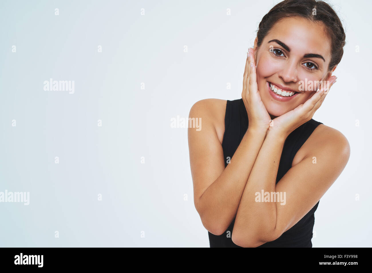Beautiful woman with nice skin, smiling at camera holding her cheeks. Copy space. Isolated Portrait Stock Photo