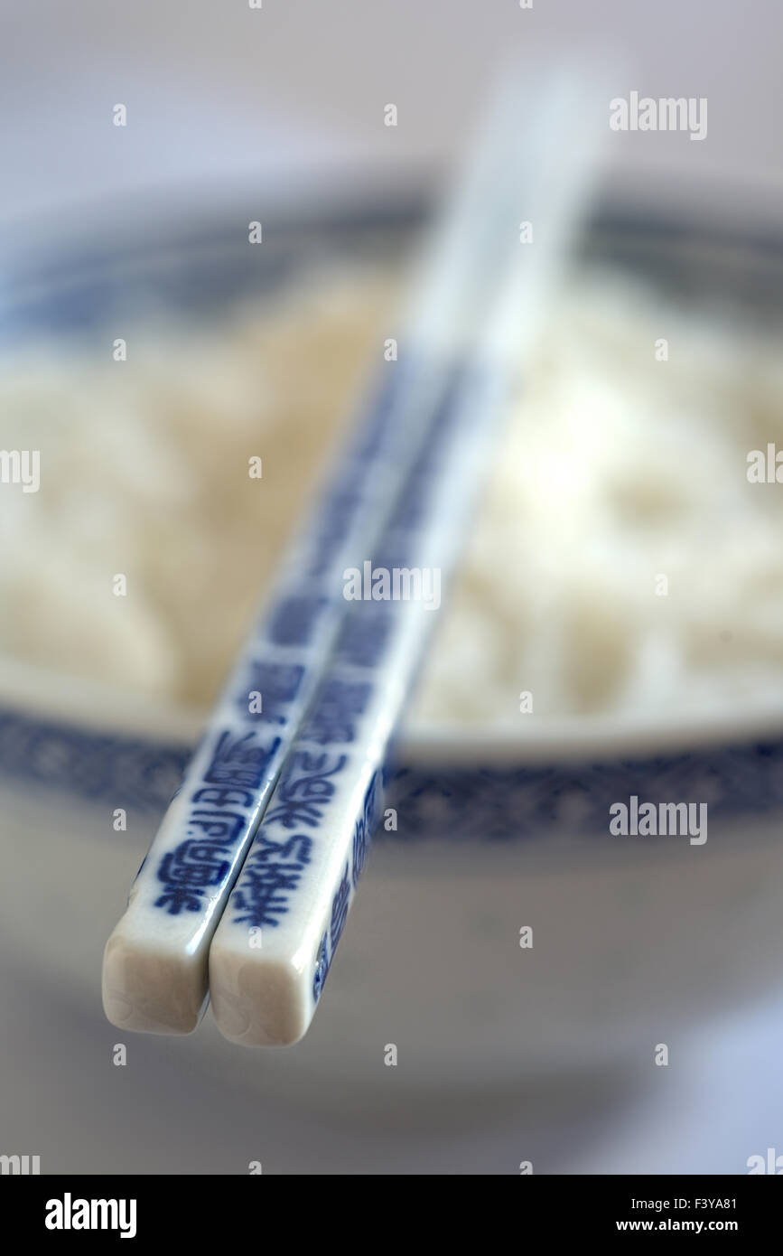 Bowl with rice and chopsticks Stock Photo