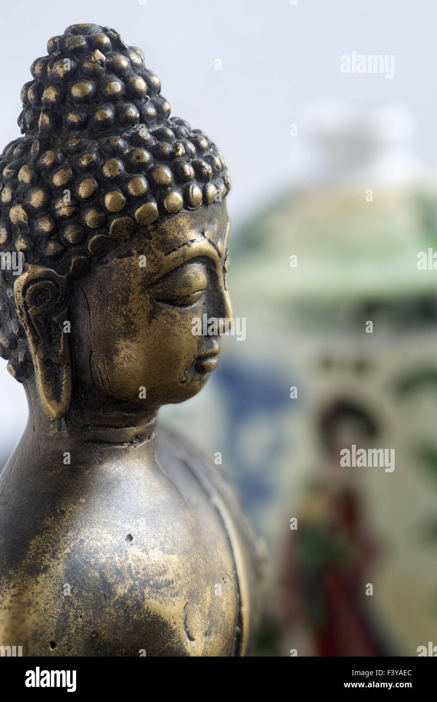 Buddha head, teapot behind Stock Photo