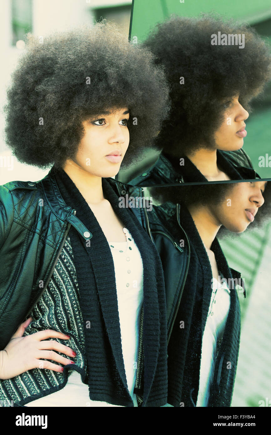 Young afro woman looking in to a mirror Stock Photo