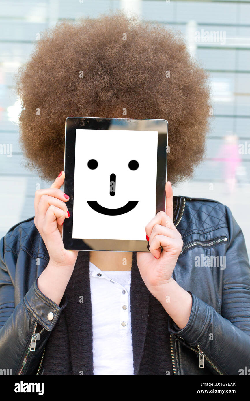 Young woman holding tablet with smiley Stock Photo