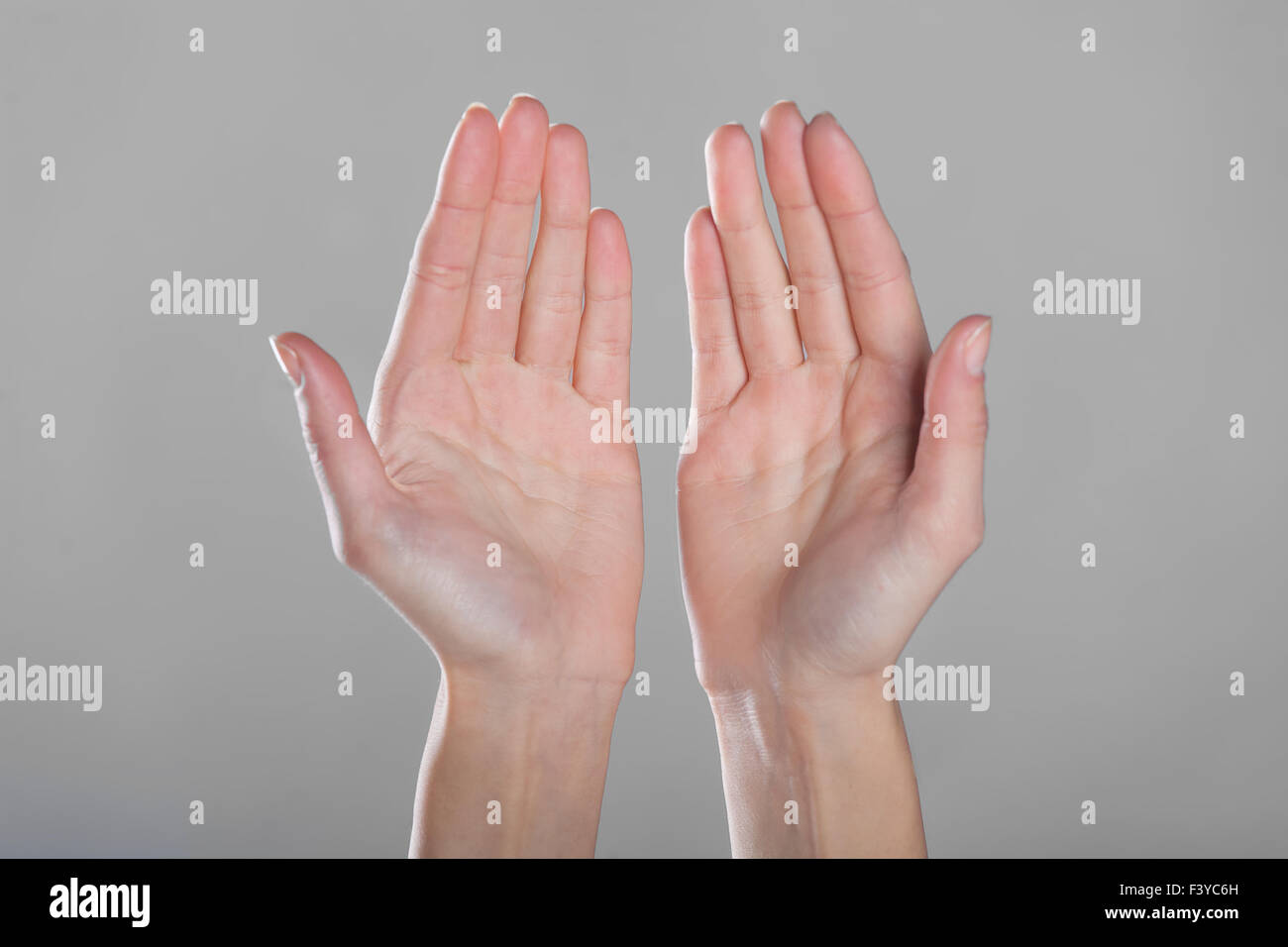Open hands on gray background Stock Photo