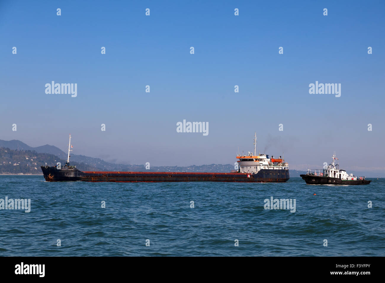 Bulk-carrier ship and tugboat Stock Photo