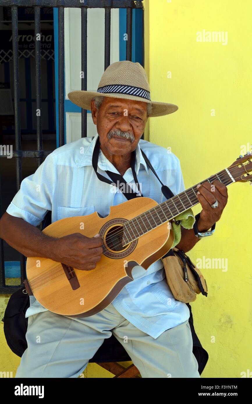 Old Cuban musician playing acoustic guitar solo on a street corner in Old Havana Cuba Stock Photo