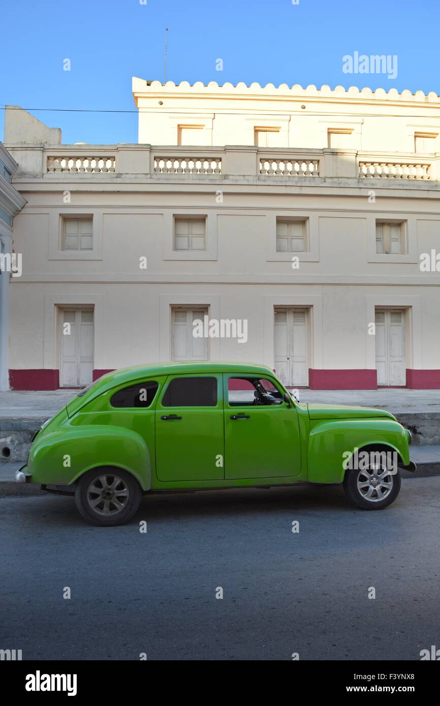 Green vintage car with tinted windows parked outside a colonial building in Santa Clara, Cuba Stock Photo